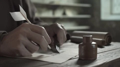 Medieval scribe scraping ink off a manuscript page with a penknife Stock Footage 337649045