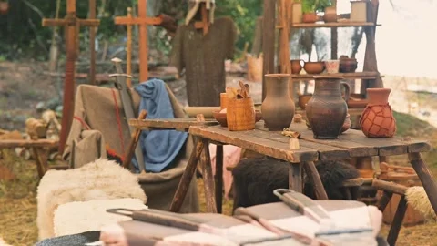 A medieval setting shows a wooden table with pottery and tools arranged neatly. Stock Footage 345031141