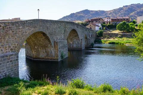 Medieval stone bridge over the River Tormes as it passes through the old village Stock Photos