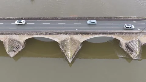 A medieval stone bridge spanning a wide river in Gien, France. Several cars Stock Footage 346704282