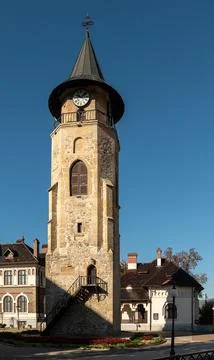 Medieval stone clock tower stands tall under clear Piatra Neamt sky Foto stock