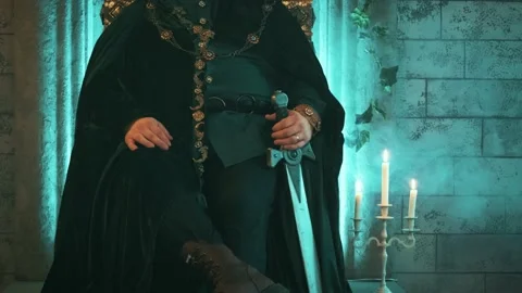 Medieval strong man king sits on old bronze throne holding sword, gold crown Stock Footage 135565726