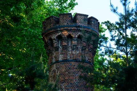 Medieval style brick tower surrounded by greenery Foto stock