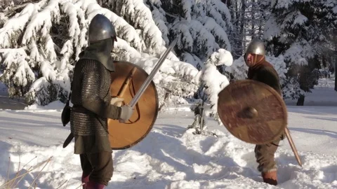 Medieval warriors fighting in a winter forest with swords in armor Stock Footage 70870838