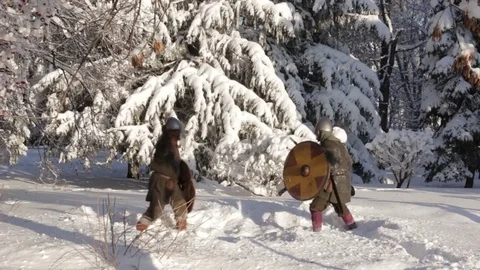 Medieval warriors fighting in a winter forest with swords in armor Stock Footage 70870839