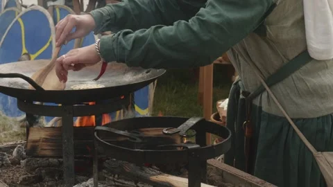 Medieval Woman Baking Flatbread on Open Fire - Historical Reenactment Loop Stock Footage 319948401