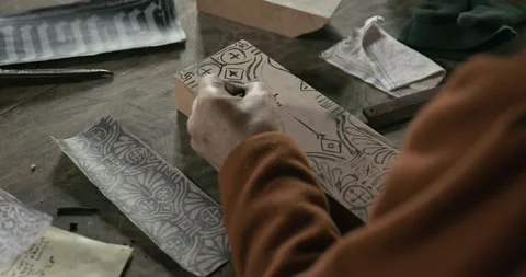 Medieval worker hand paints pattern onto printing block for textile printing #2 Stock Footage 320556774