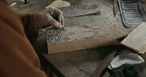Medieval worker hand paints pattern onto printing block for textile printing #3 Stock Footage 320557340