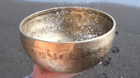 Meditating with beating a copper singing bowl from Nepal filled with water  Stock Footage 86489047