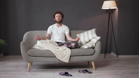 Meditation before bedtime. Young Guy Sits in a Lotus Position. Stock Footage 159077381