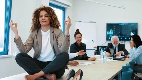 Meditation in office while her colleagues bother her and make noise Stock Footage 170174401