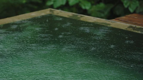 Meditative rhythm of rain falling on the surface of a swimming pool. Stockbeeldmateriaal 336057217