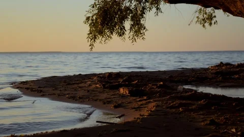 Meditative shot of the setting summer sun, calm waves on the sandy shore after Stock Footage 255074099