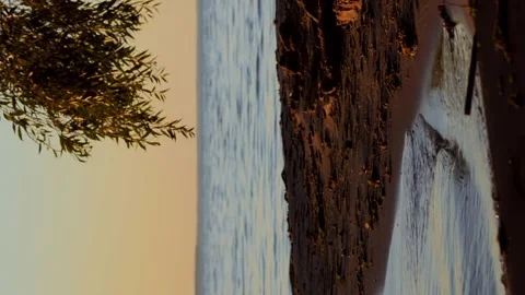 Meditative shot of the setting summer sun, calm waves on the sandy shore after Stock Footage 256993934