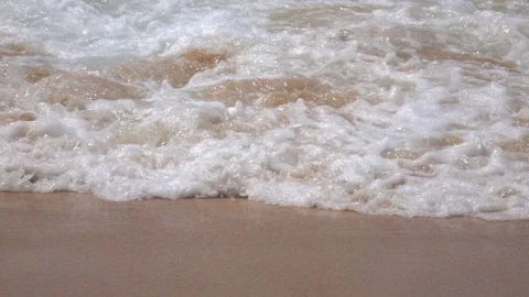 Meditative slow motion of flat sea wave with white foam on brown sand beach Stock-Footage 69822845