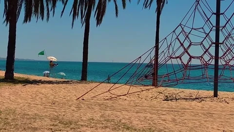 Mediterranean Beach Playground With Palm Trees and Sailboat Stock Footage 336823580