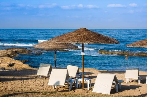 Mediterranean palm beach with empty sunbeds against hotel in morning, Paphos Stock Photos