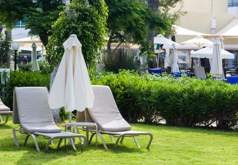 Mediterranean palm beach with empty sunbeds against hotel in morning, Paphos, Stock Photos