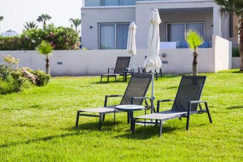 Mediterranean palm beach with empty sunbeds against hotel in morning, Paphos, Stock Photos