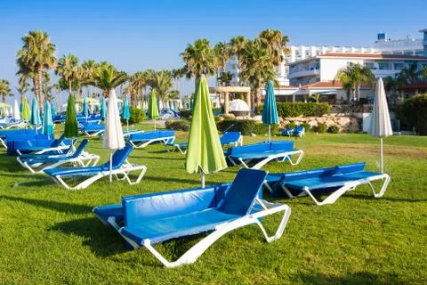Mediterranean palm beach with empty sunbeds in morning, Paphos, Cyprus Stock Photos