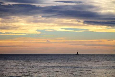 Mediterranean seaside sunset behind the clouds. Stock Photos