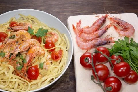 Mediterranean shrimps, cherry tomatoes and parsley, basic ingredients that co Stock Photos