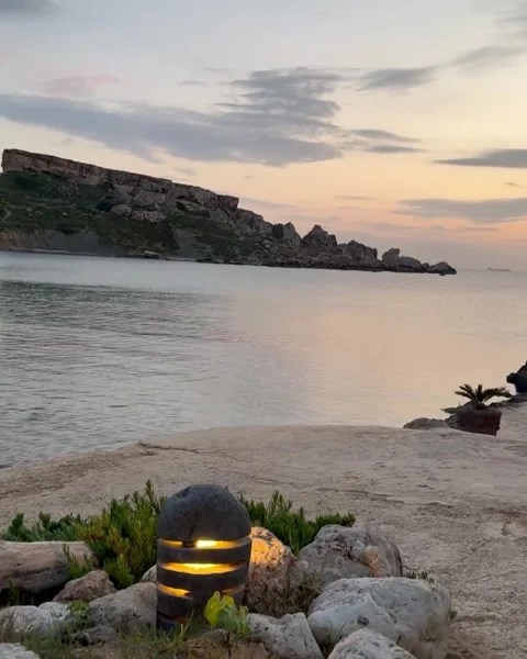Mediterranean Sunset Cove with Illuminated Stone Lantern Stock Footage 310334236