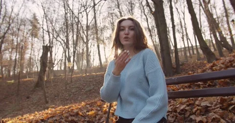 Medium 4k shot of young pretty curly brunet female in autumn park Stock Footage 144979598