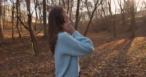 Medium 4k shot of young pretty curly brunet female in autumn park Stock Footage 144979610