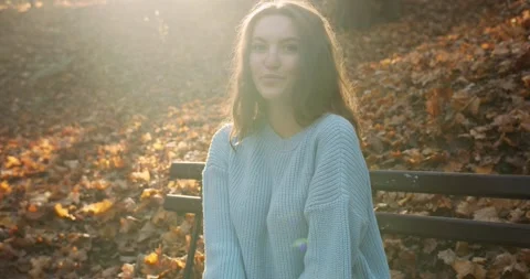 Medium 4k shot of young pretty curly brunet female in autumn park Stock Footage 144979623
