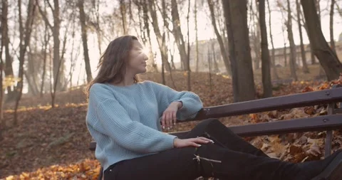 Medium 4k shot of young pretty curly brunet female in autumn park Stock Footage 144979662