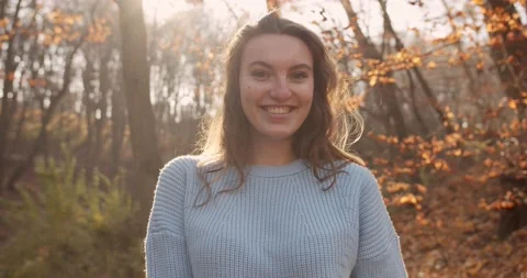 Medium 4k shot of young pretty curly brunet female in autumn park Stock Footage 144979745