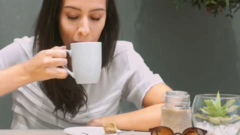 Medium 4k video of a young, beautiful, Latin Hispanic woman drinking coffee in g Video stock 201094384