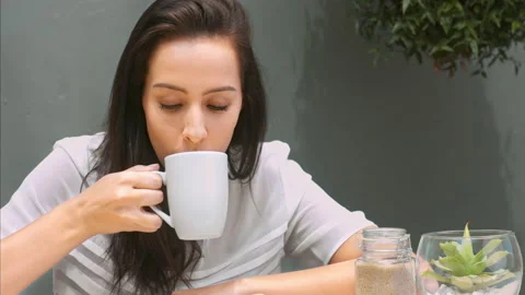 Medium 4k video of a young, beautiful, Latin Hispanic woman drinking coffee in g Stock Footage 201095138
