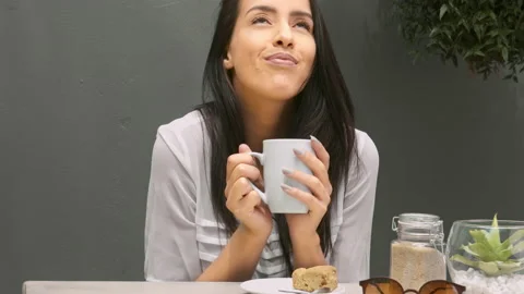 Medium 4k video of a young, beautiful, Latin Hispanic woman drinking coffee in g Stock Footage 201095596