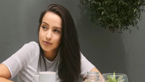 Medium 4k video of a young, beautiful, Latin Hispanic woman drinking coffee in g Stock Footage 201097033