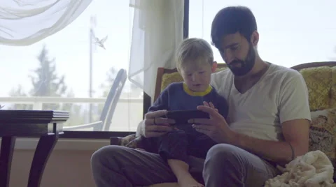 Medium on adorable dad and son playing with cell phone Stock Footage 66689644