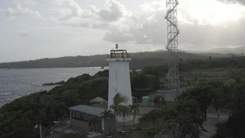 Medium aerial circles around Toco lighthouse to reveal Atlantic Ocean Видео 261923759