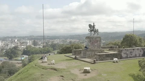 Medium aerial circles low around front of statue on Morro del Tulcán in Popayan Stock Footage 105475810