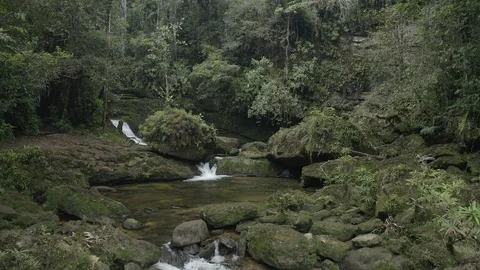 Medium aerial pushes forward towards a waterfall on the Fin del Mundo hike 스톡 동영상 104884628