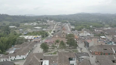 Medium aerial slowly pushes over the main church and plaza of San Agustin Stock Footage 104790644