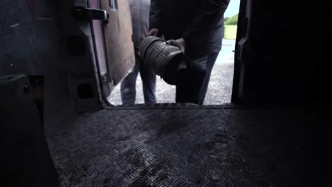 Medium angle loading Catalytic converter into a van with a client or two Stock Footage 200681476