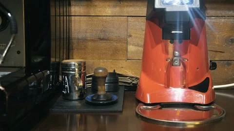Medium close up of barista hand inserts a holder into a coffee grinder Stock Footage 127586903