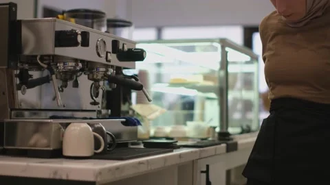 Medium close up of barista puts on an apron near the coffee machine Stock Footage 232204186