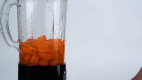 Medium close up, blending carrot juice from piece from carrot. Видео 137769445