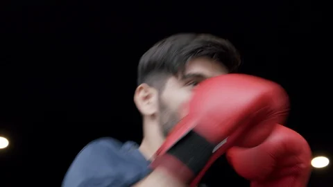 Medium close up of Caucasian young man wearing boxing gloves punching Stock Footage 121492282