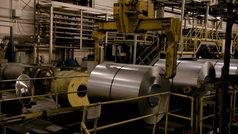 Medium Close Up of Crane picking up rolled steel in Modern Mill Stock Footage 89944552