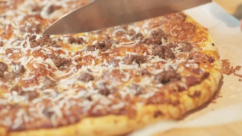 Medium close up cutting a pizza into 8 portion using a sontoku knife Stock Footage 127972566