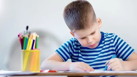 Medium close-up diligent concentrated little child boy drawing picture using Stock Footage 105927858
