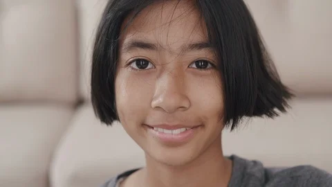 Medium close up on face Asian little girl smiling happily at home Stock Footage 123808174